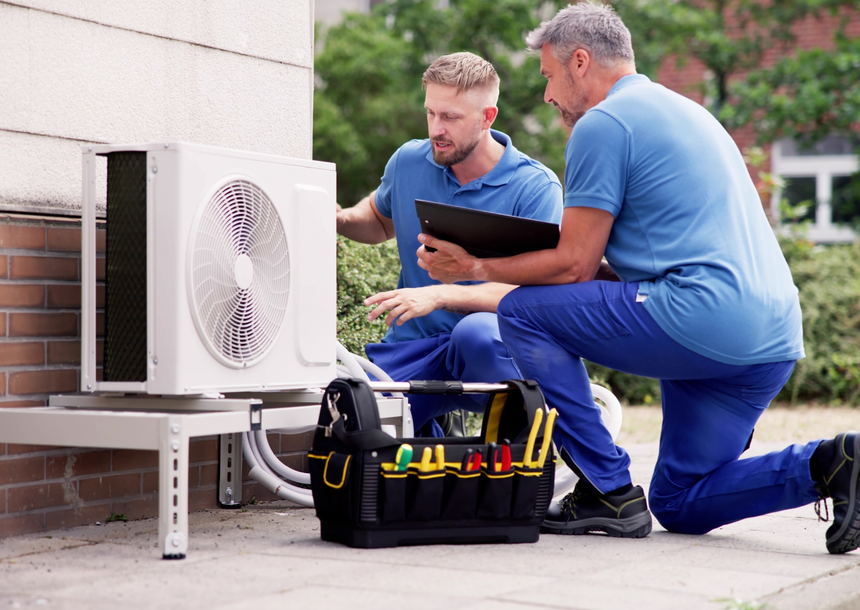 Two men installing a new heat pump.