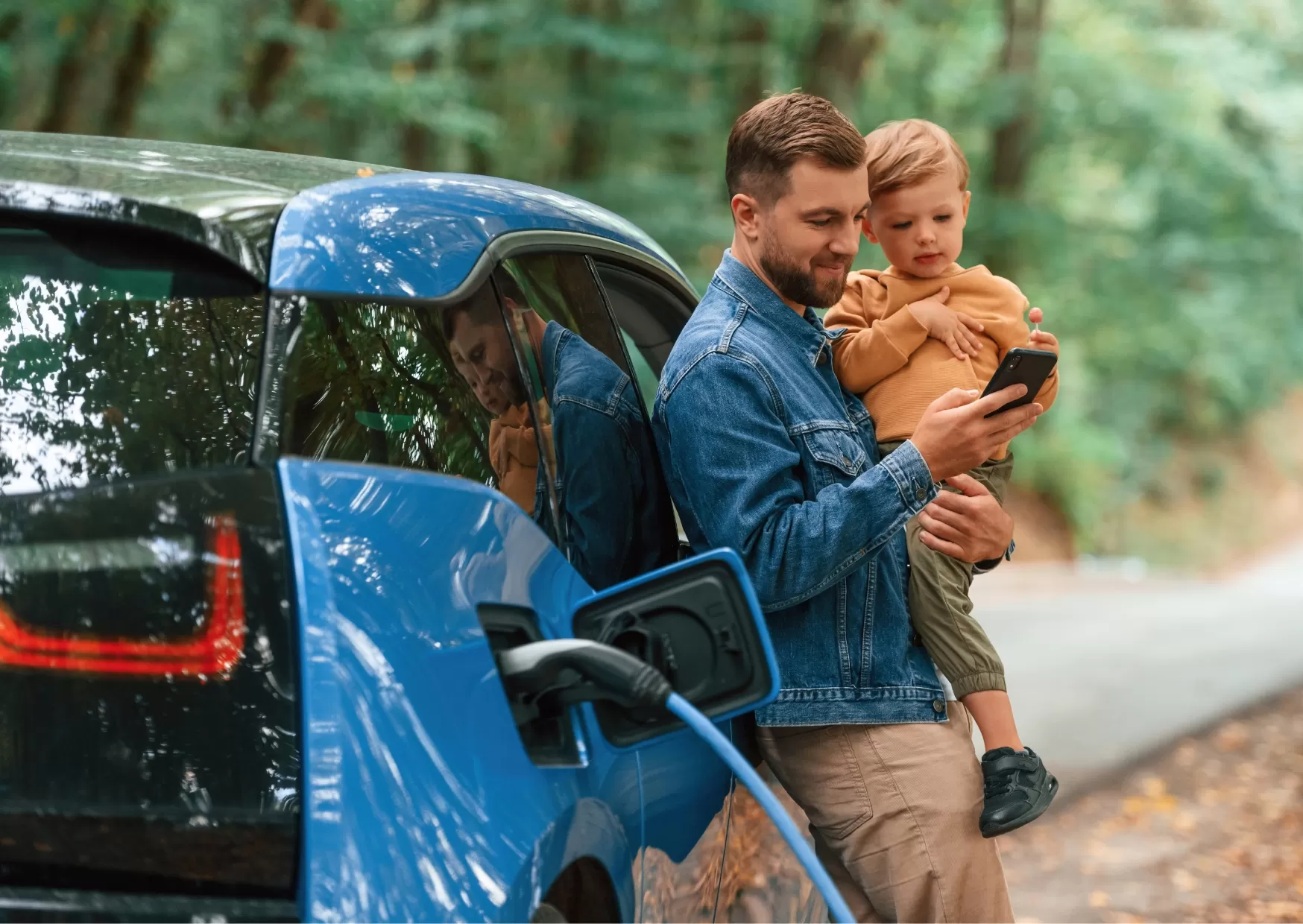 Dad and son relaxing while charging an EV.