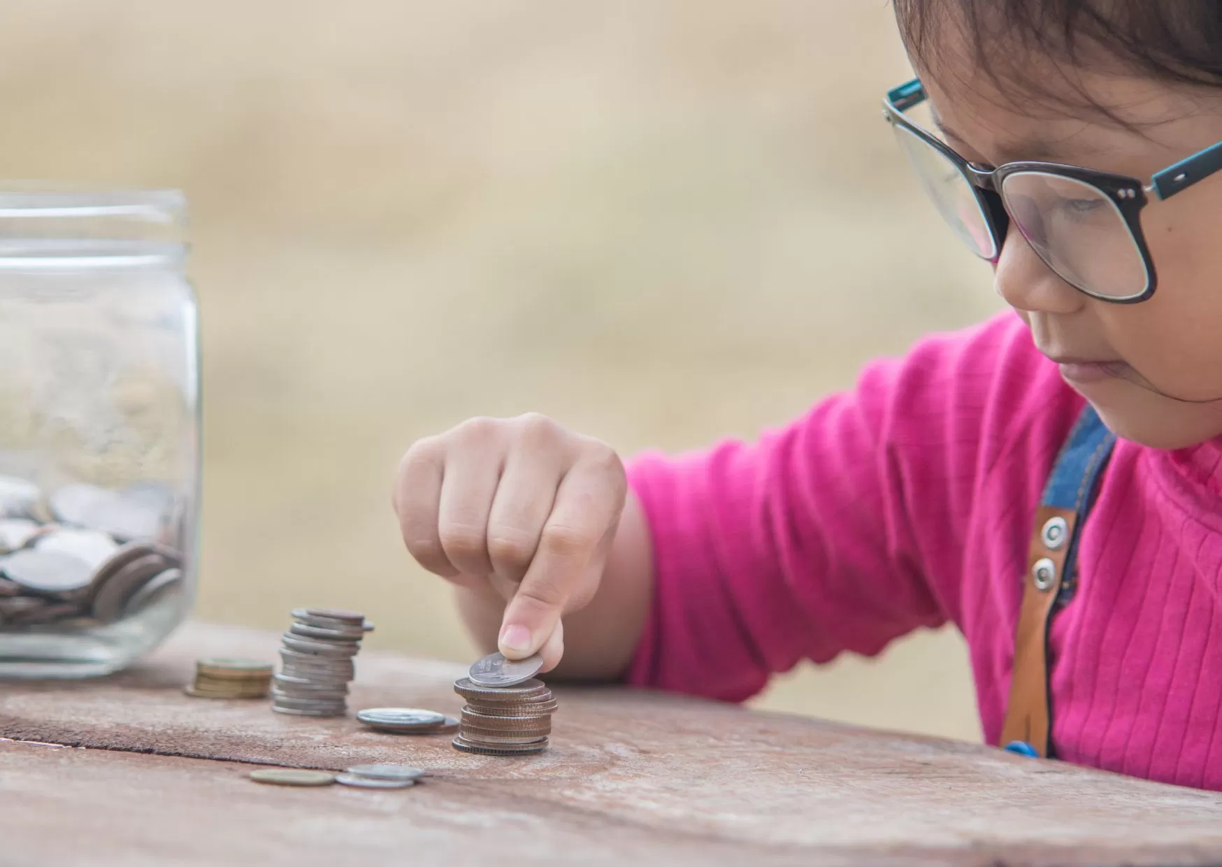 Young Asian child counting coins